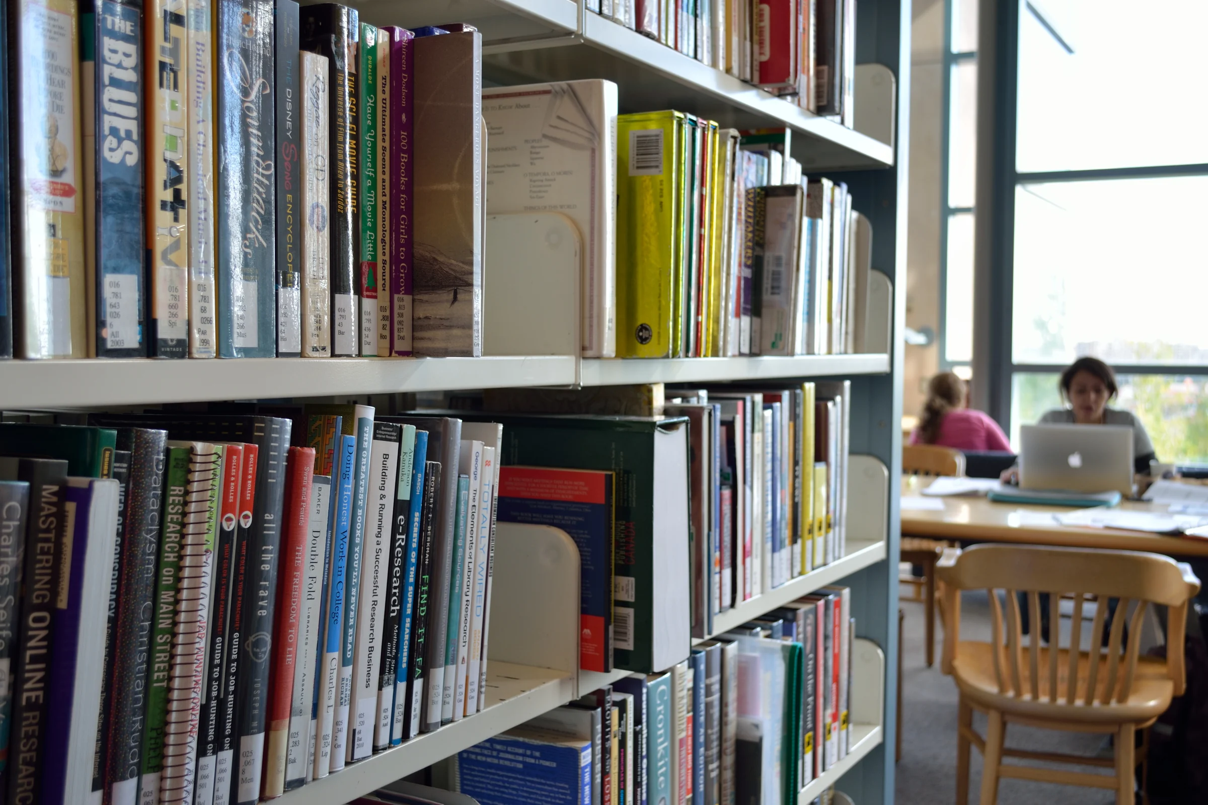Bookshelves and readers in a library reading room